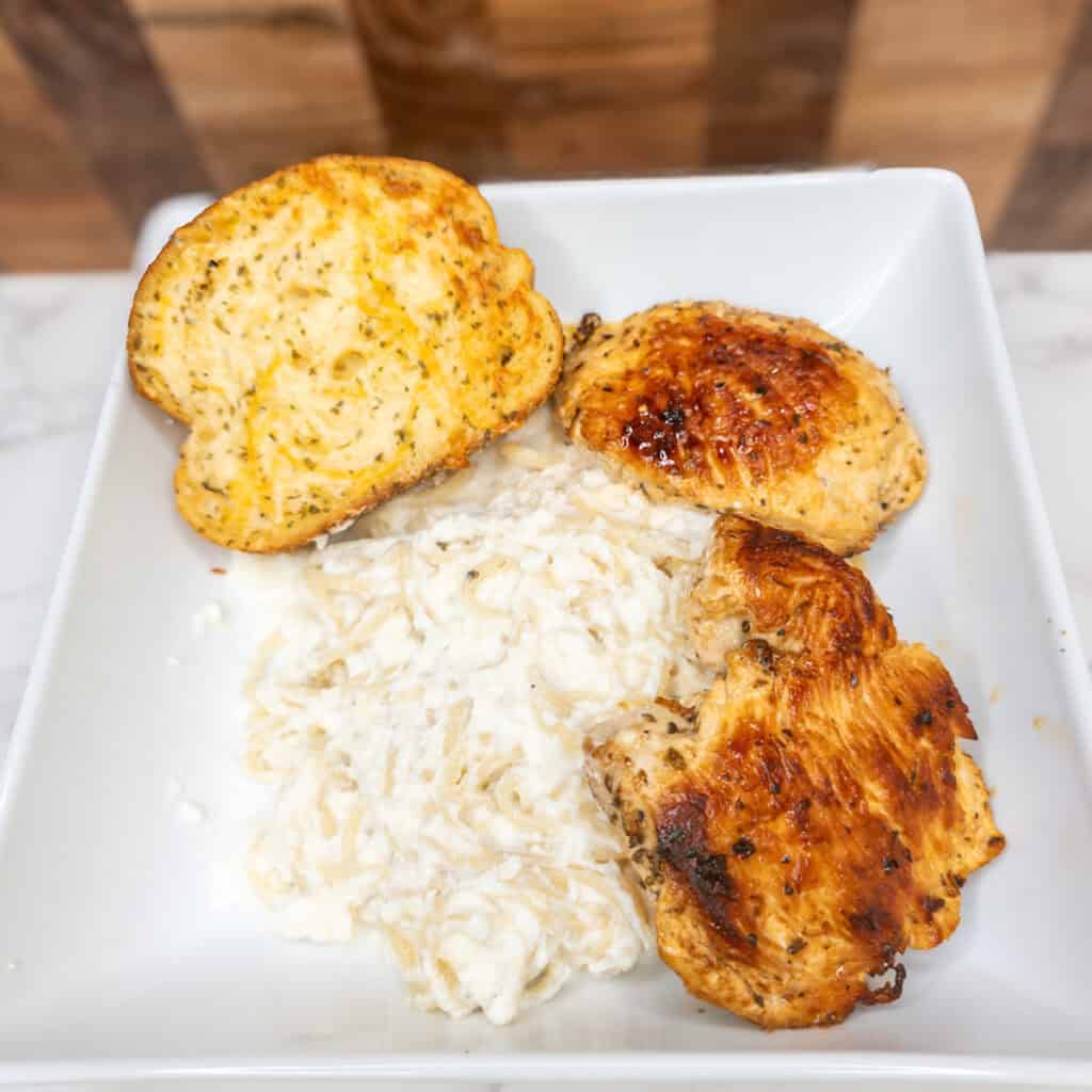 Grilled chicken with garlic bread and creamy mashed potatoes, classic Italian cooking ideas and recipes.