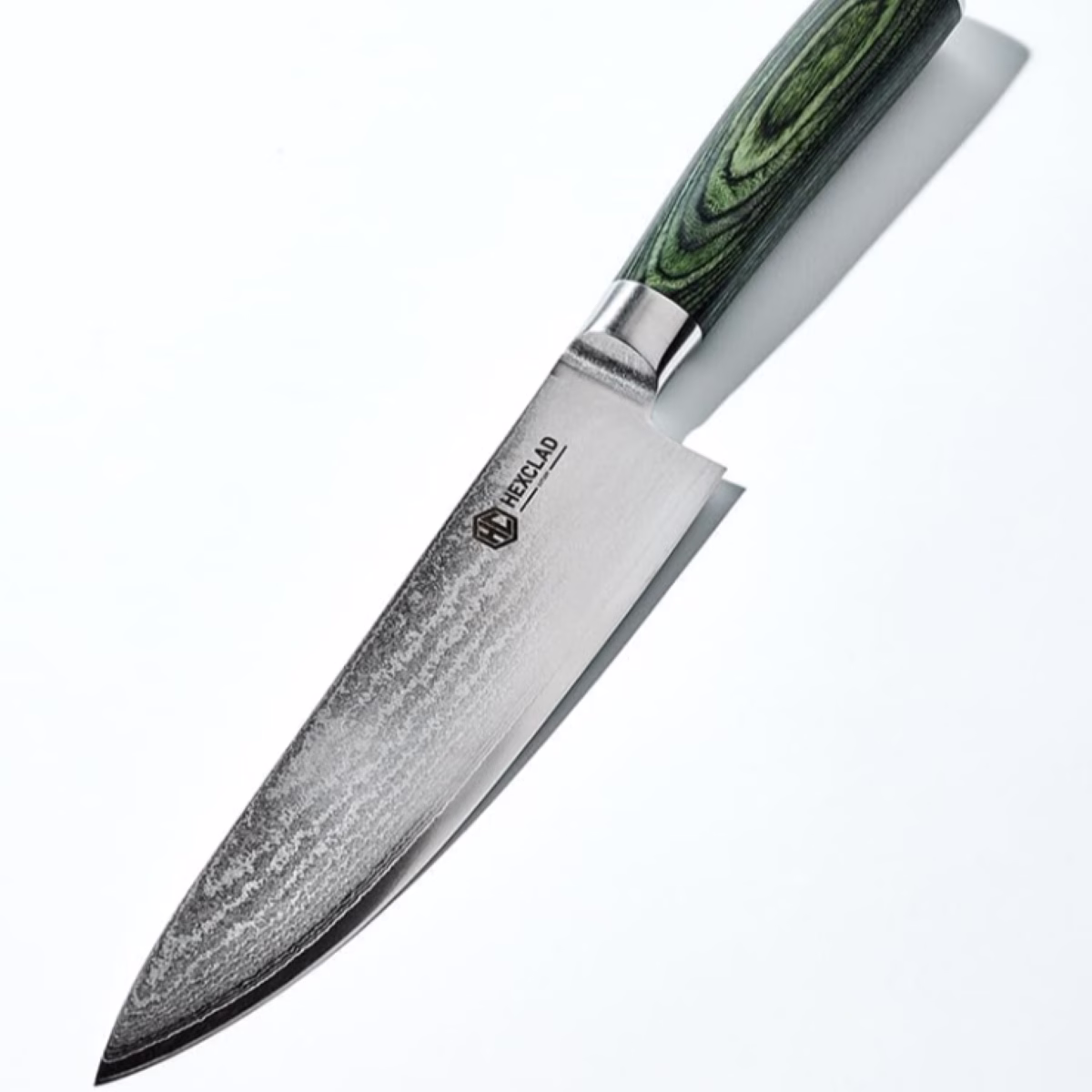 A knife with a green handle sitting on a white surface