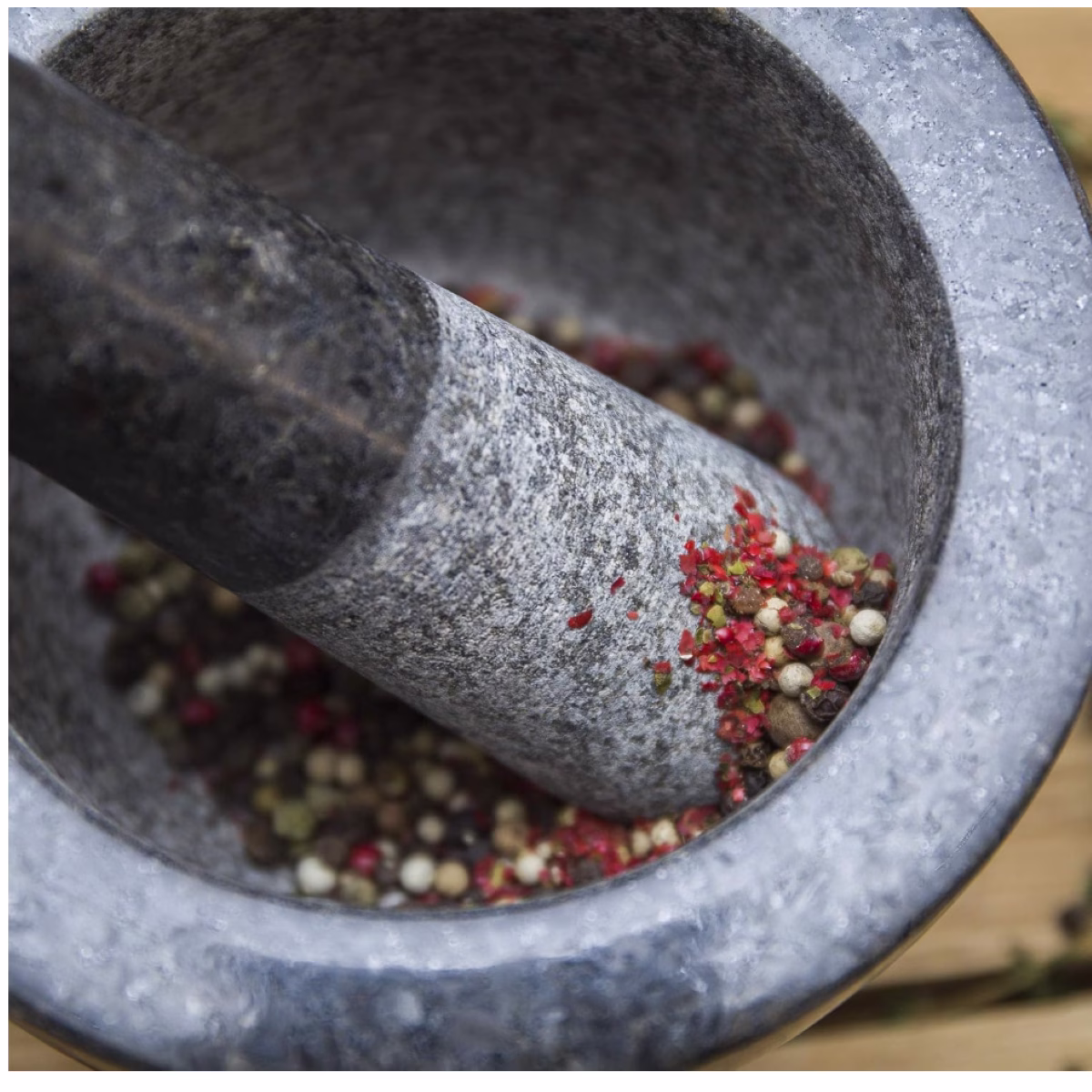 A mortar with red and white pepper in it
