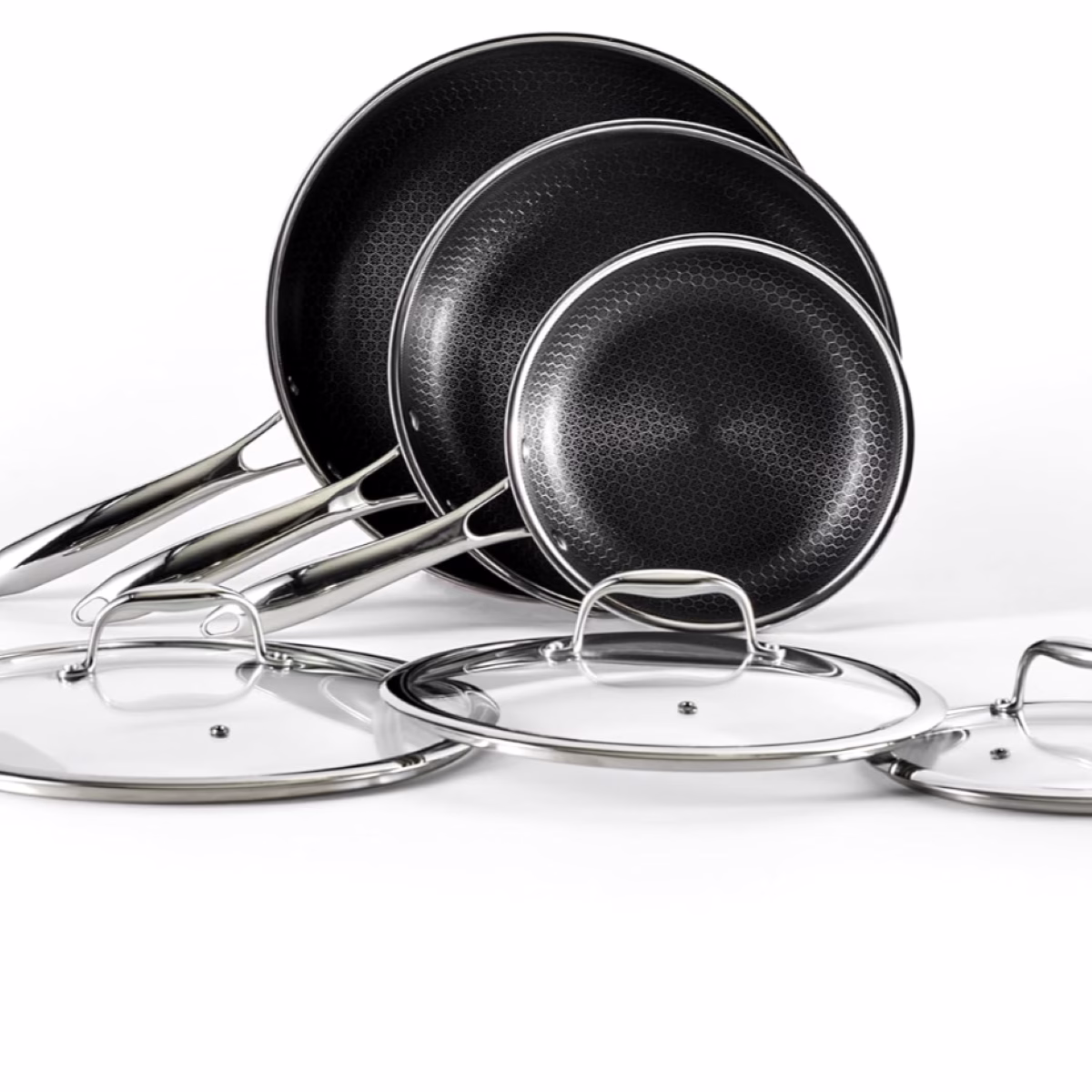 A set of four black pans and lids