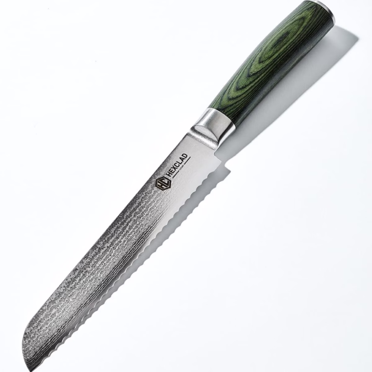 A knife with a green handle sitting on a white surface