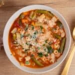 A bowl of hearty Italian minestrone soup with fresh vegetables and pasta, topped with grated cheese and herbs for authentic flavor.