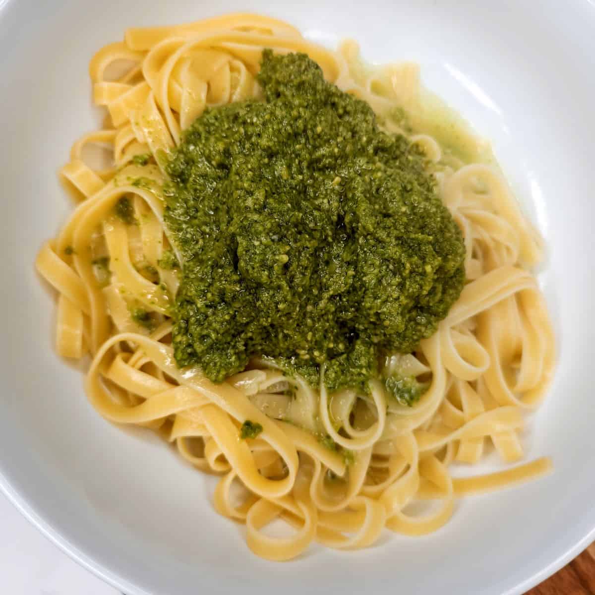 Creamy pesto pasta with fresh basil and cheese on a white plate, Italian cooking ideas and recipes.