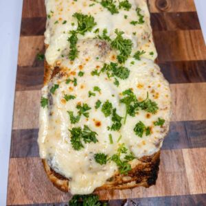 Chicken topped with melted cheese and fresh herbs, perfect for Italian cooking recipes.