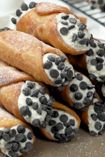 Delicious Classic Italian cannoli filled with cream and chocolate chips on a serving platter.