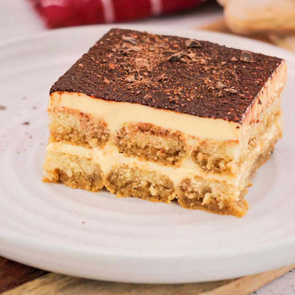Rich Italian tiramisu dessert recipe with coffee-soaked ladyfingers and mascarpone cheese, topped with cocoa powder.