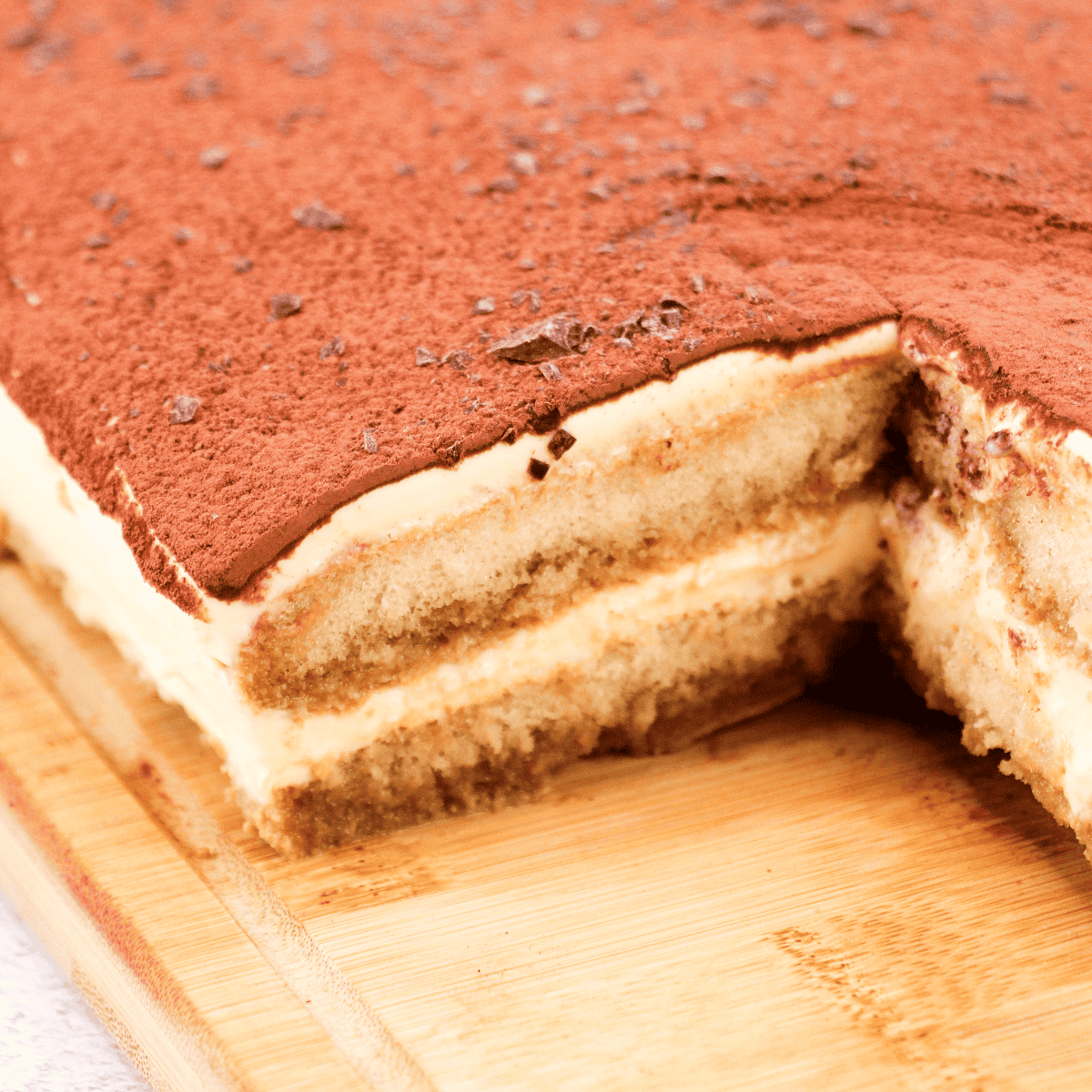 Rich Italian tiramisu with cocoa powder sprinkled on top, creamy layered dessert for Italian cooking ideas and recipes.
