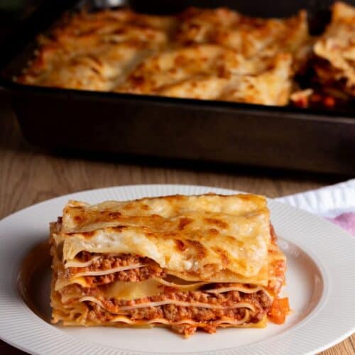 lasagna al forno served on a white plate with meat, cheese, pasta layers