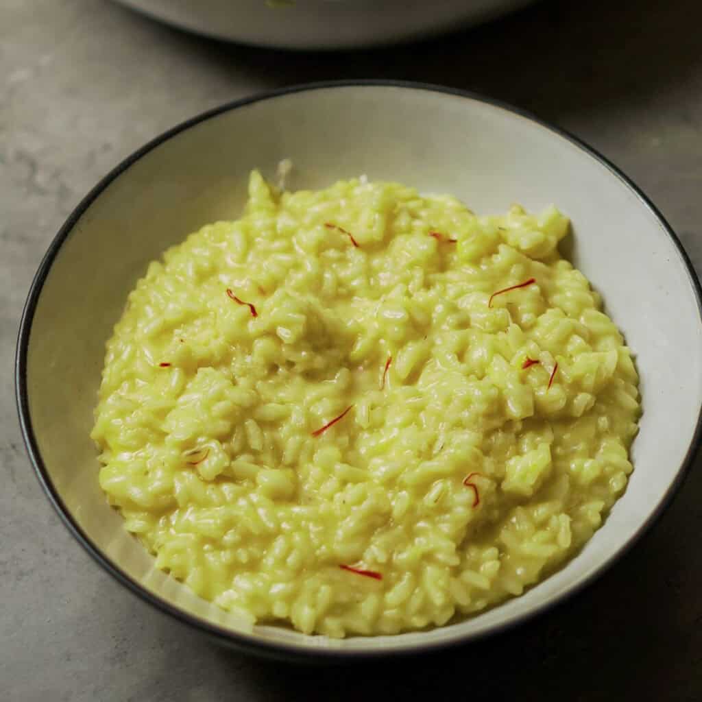 Risotto alla Milanese in a white bowl, perfect for authentic Italian cooking ideas and recipes.