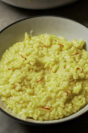 Risotto alla Milanese in a white bowl, perfect for authentic Italian cooking ideas and recipes.