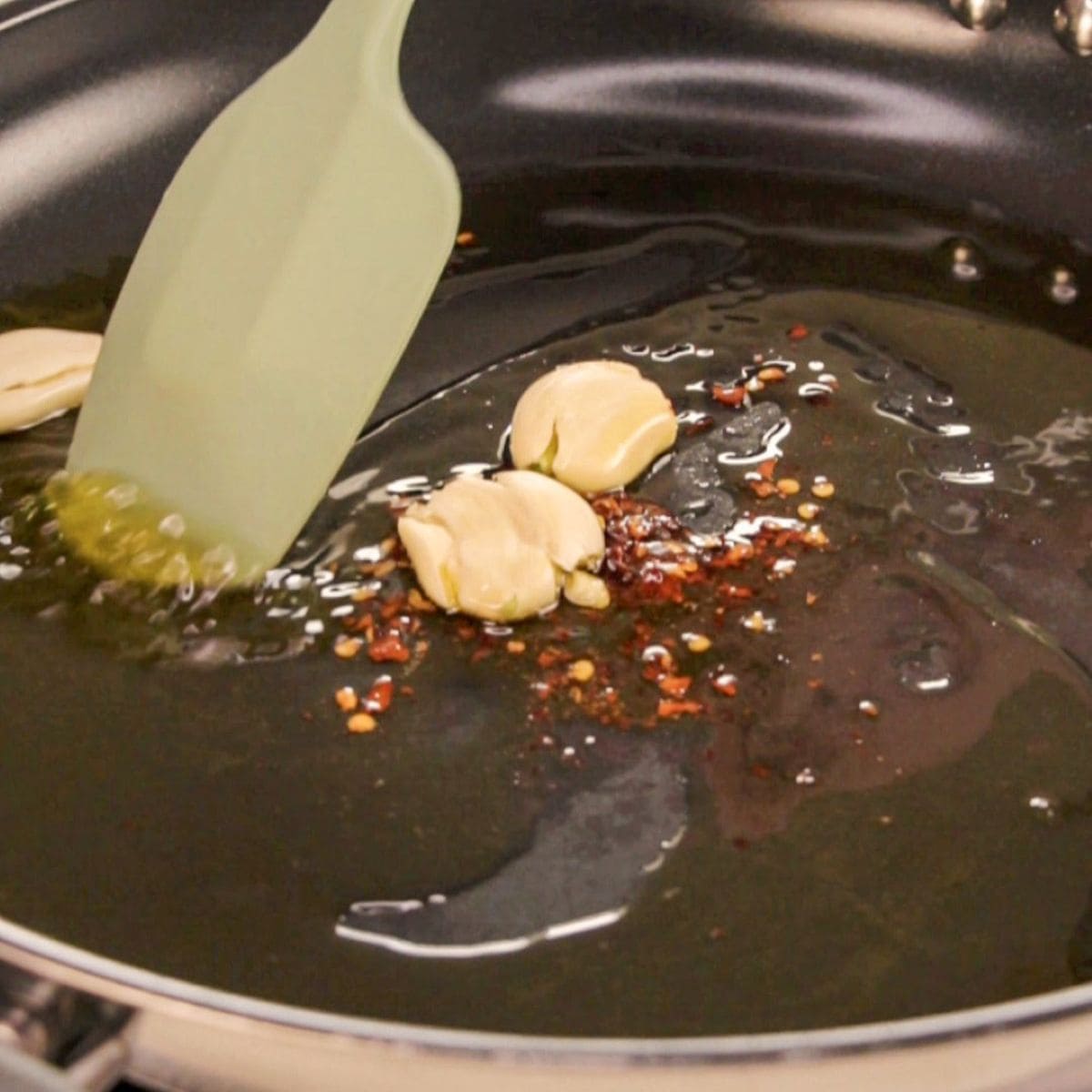Garlic and chili being sautéed in olive oil for Italian recipes.