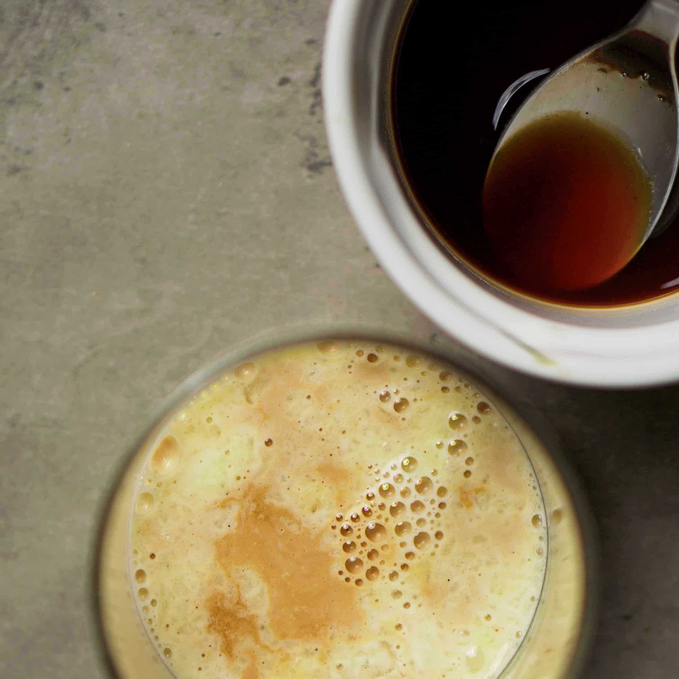 Traditional Italian coffee and egg drink served in a white cup with a spoon.