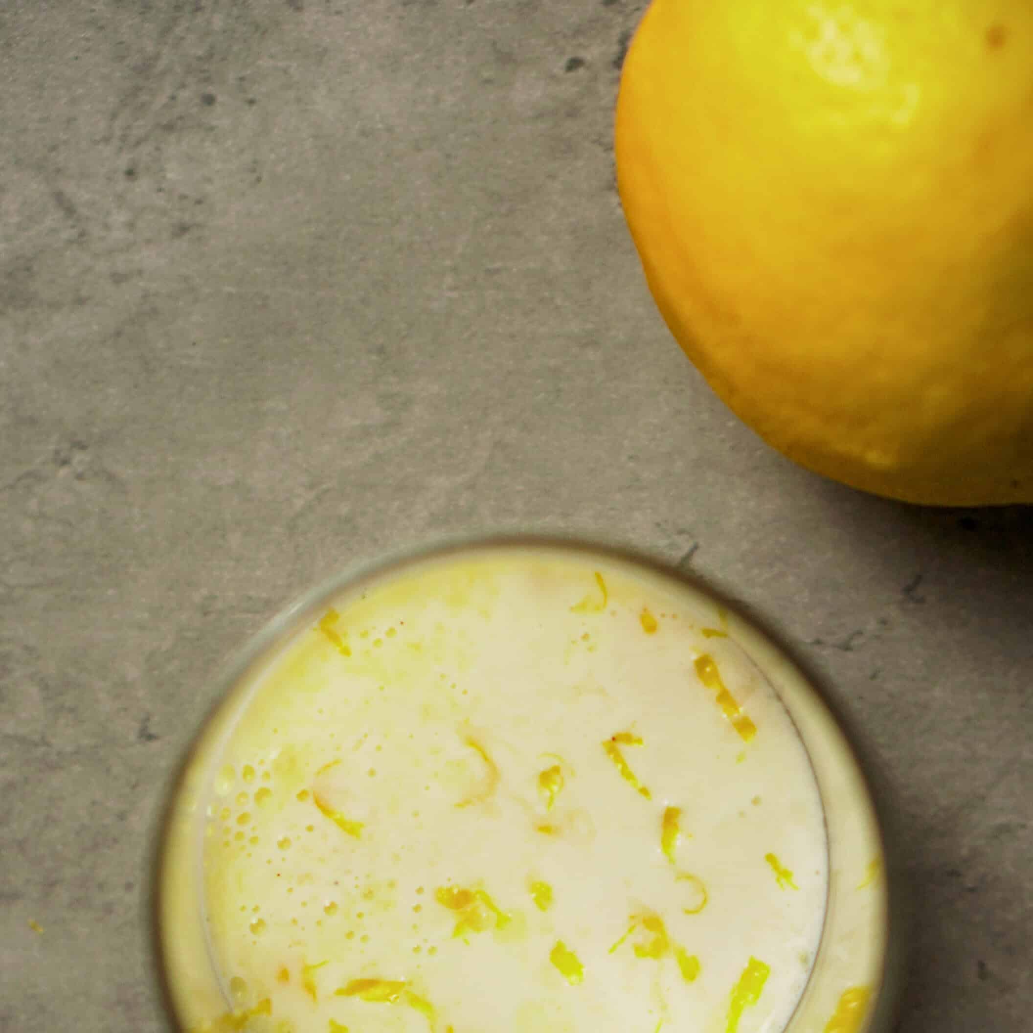 Freshly squeezed lemon juice in a glass with a whole lemon nearby, perfect for Italian recipes.